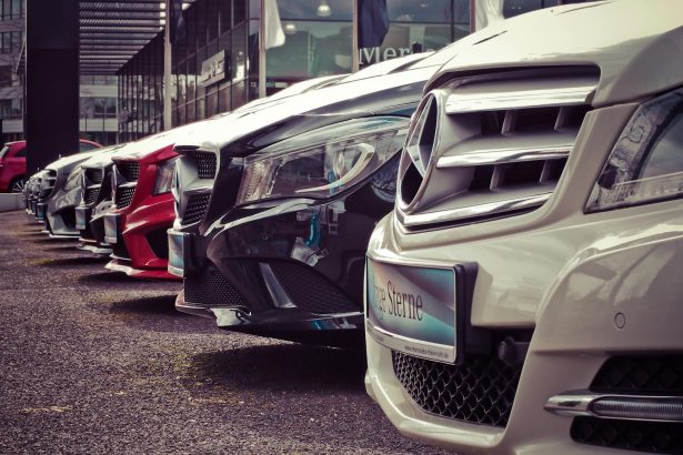 Luxury cars lined up at an outdoor dealership, showcasing sleek designs.
