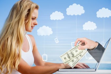 Złożony obraz ładnej blondynki używającej swojego laptopa na plaży z ręką trzymającą pieniądze