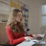 A dedicated female freelancer working on a laptop from her home office.