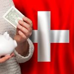 Szwajcarka z bankiem pieniężnym na tle szwajcarskiej flagi