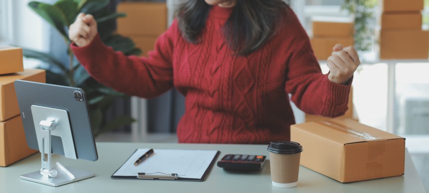 Startup MŚP mała firma przedsiębiorca niezależny Azjatka używa laptopa z pudełkiem Wesoły sukces Azjatycka kobieta podnosi rękę do góry opakowanie marketingu internetowego i dostawę Koncepcja pomysłu MŚP