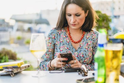 Kobieta używająca telefonu komórkowego przy stole w restauracji