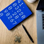 black click pen beside MacBook Pro on table