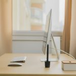 Apple iMac on wooden desk near window