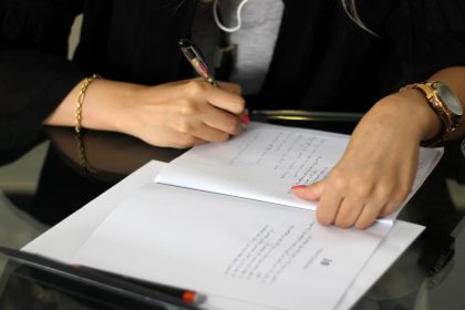 a person writing on a piece of paper