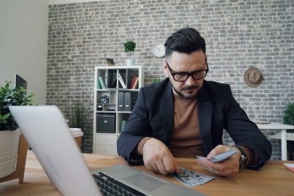a man sitting at a table in front of a laptop