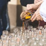 person filing glass bottle lot