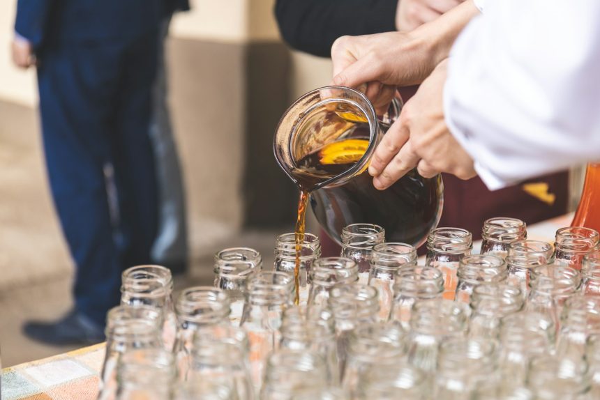 person filing glass bottle lot