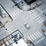 an overhead view of a city intersection with a car