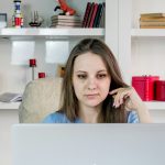 a woman sitting in front of a laptop computer